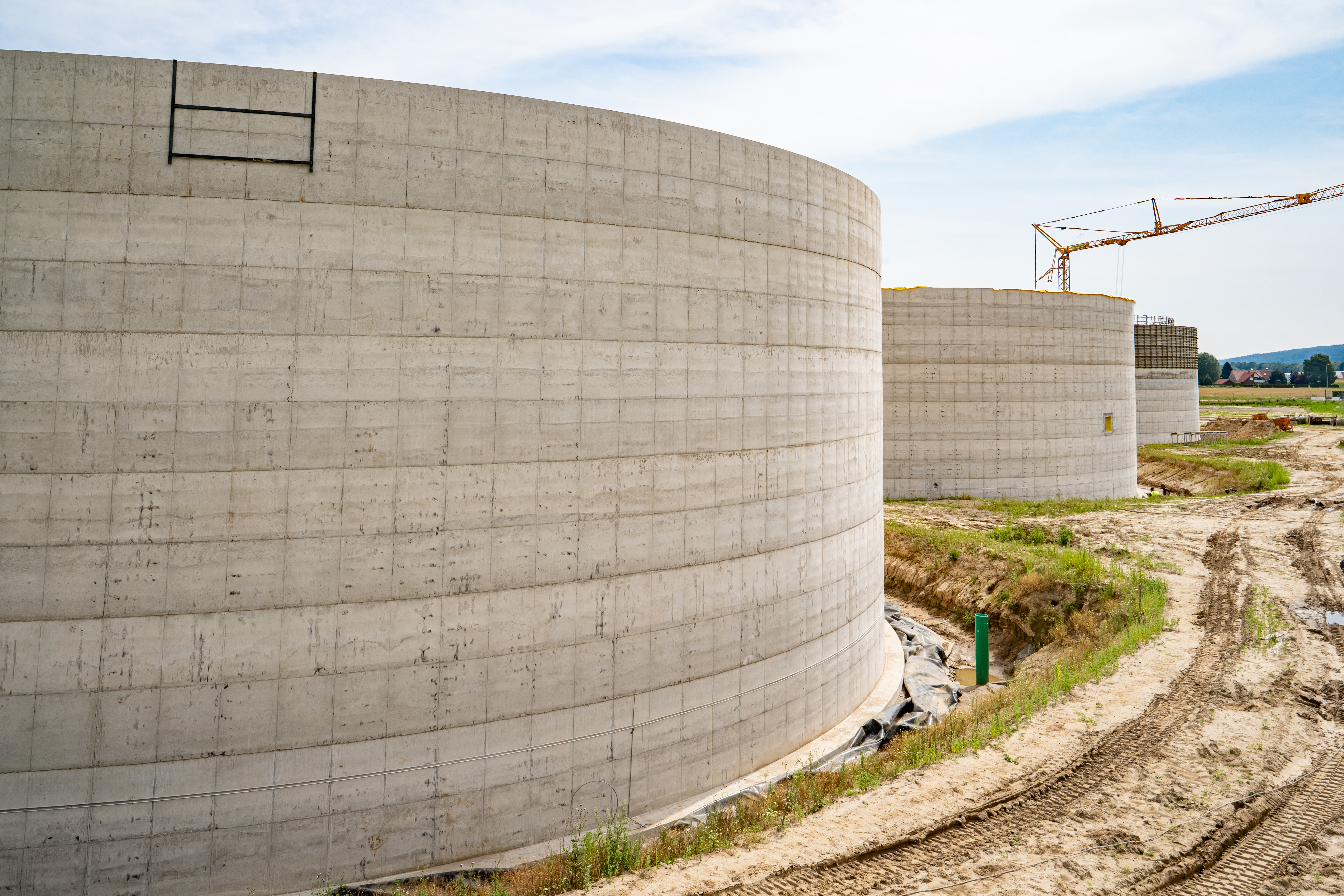 Construction of a biogas plant, with large concrete tanks.