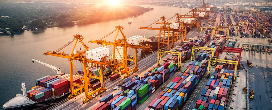 Aerial view of a container port with cranes loading and unloading shipping containers